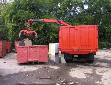 Business staff loading sorted recycling into a collection vehicle
